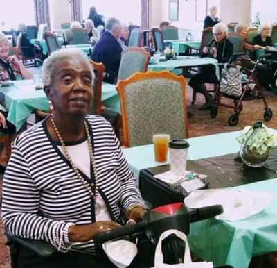 Senior woman smiles in the dining room at a senior living facility in Fairfield, Ohio.