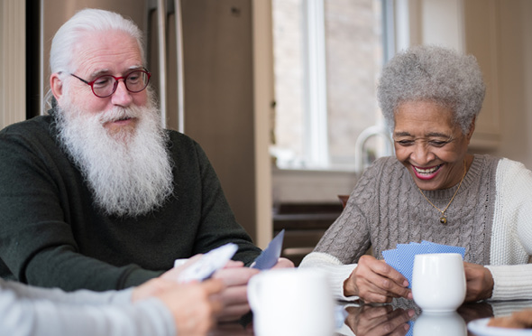 Two residents in a Sonida Senior Living independent and assisted living community enjoying a game of cards.