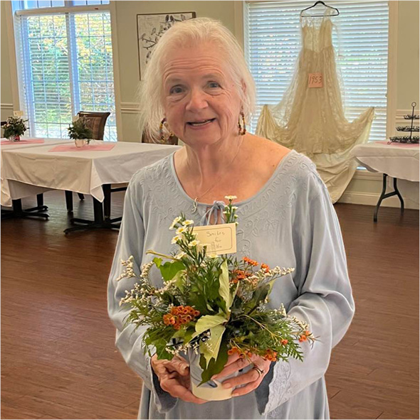 senior woman holds a flower bouquet while smiling