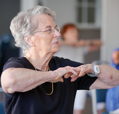 senior woman does stretches during an exercise class