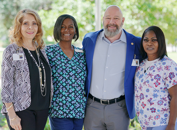 A Sonida Senior Living team posing together for a photo outside an assisted living community.