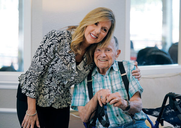 A Sonida Senior Living team member hugging a resident who is smiling.
