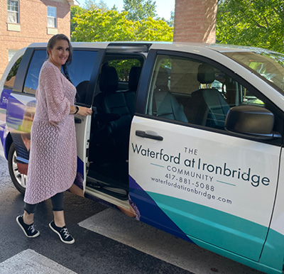 A Sonida Senior Living team member opening the sliding door of an assisted living community transportation van.