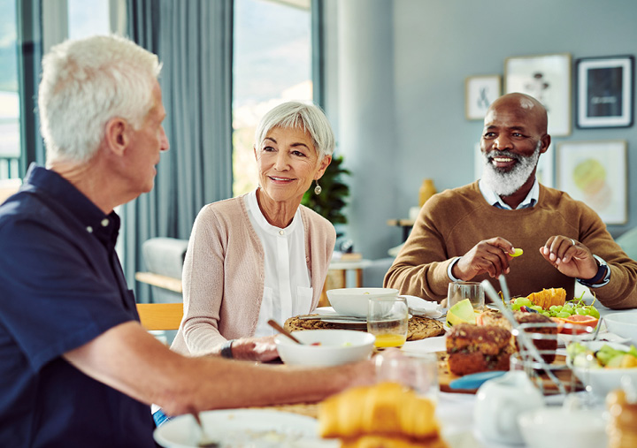 A group of independent living residents enjoying a meal together in the dining room of a Sonida Senior Living community.