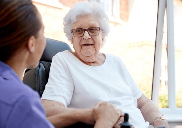A Sonida Senior Living team member engaging with a smiling resident at an independent and assisted living community.
