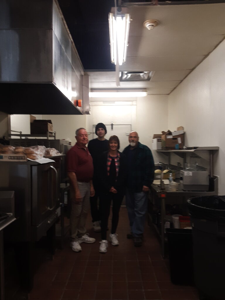 Four team members at The Waterford at Fairfield pose in their community's kitchen during a winter storm