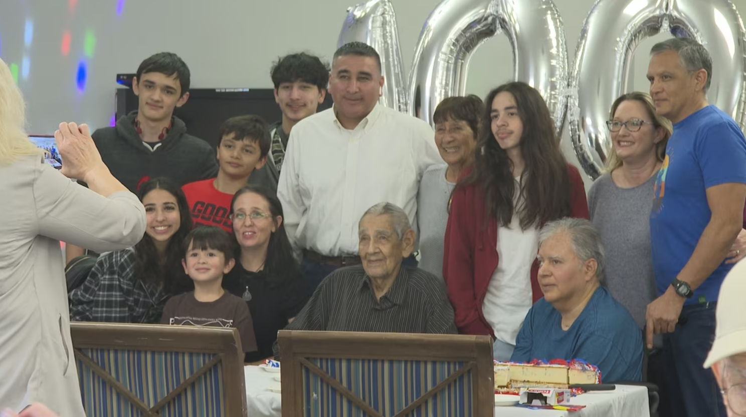 senior man celebrates his 100th birthday with family and friends at his senior living community
