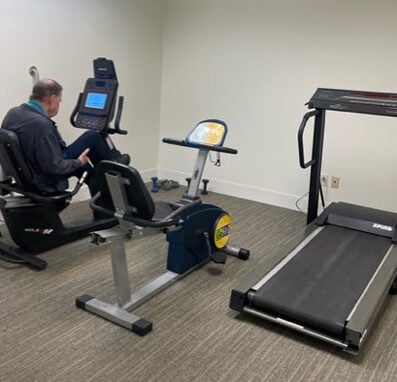 On-site gym includes a treadmill and two bikes, with one of them being used by a senior man