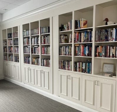 white cabinets filled with books in a senior living community
