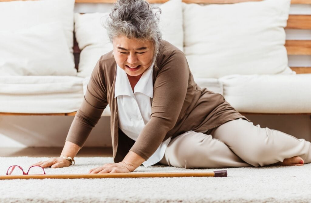 Asian senior woman falling down and lying on the floor at her home