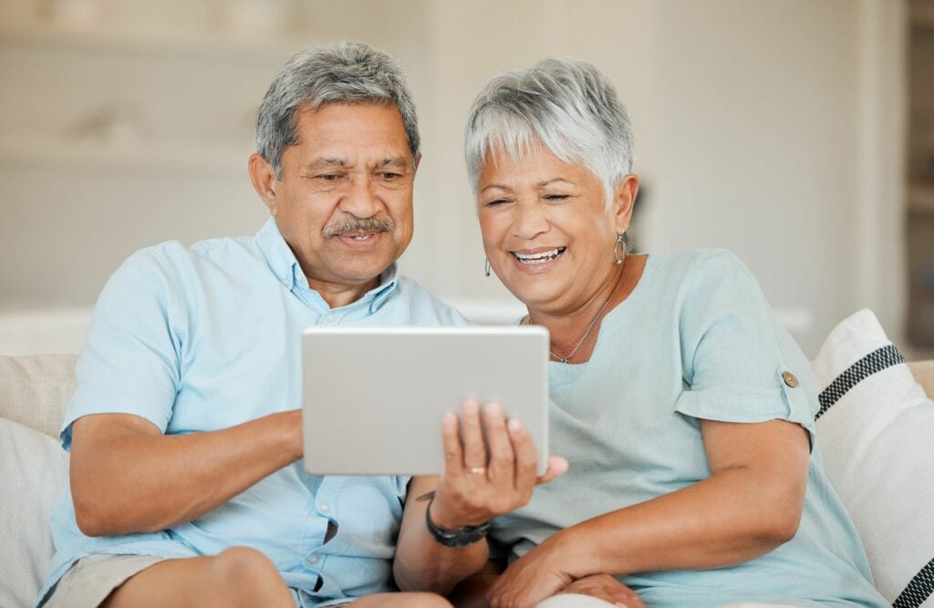 Shot of a happy senior couple relaxing and using a tablet on the sofa at home