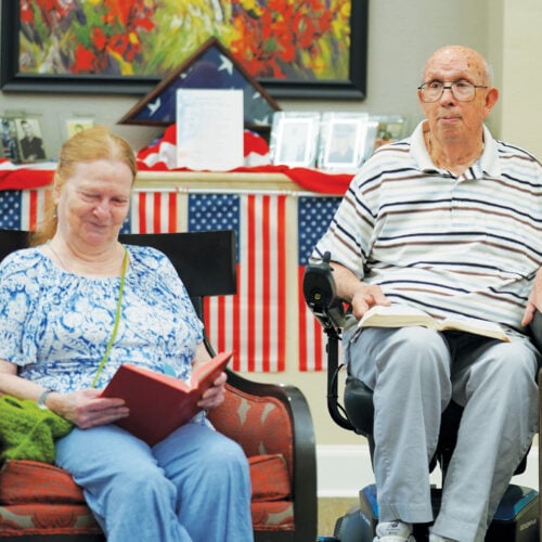 senior woman and senior man participate in Bible study together at a senior living community