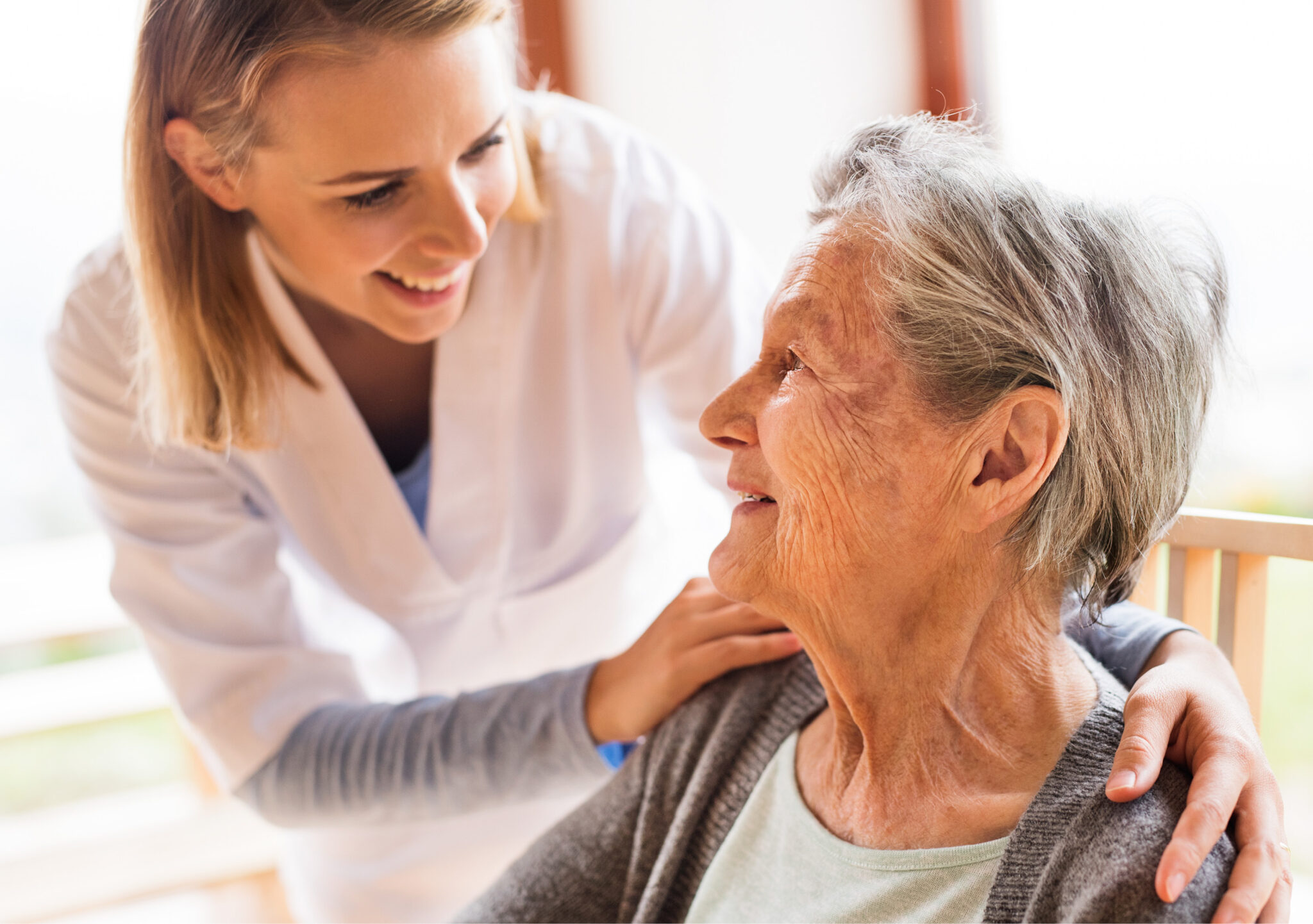 A senior living nurse talks to an elderly woman.