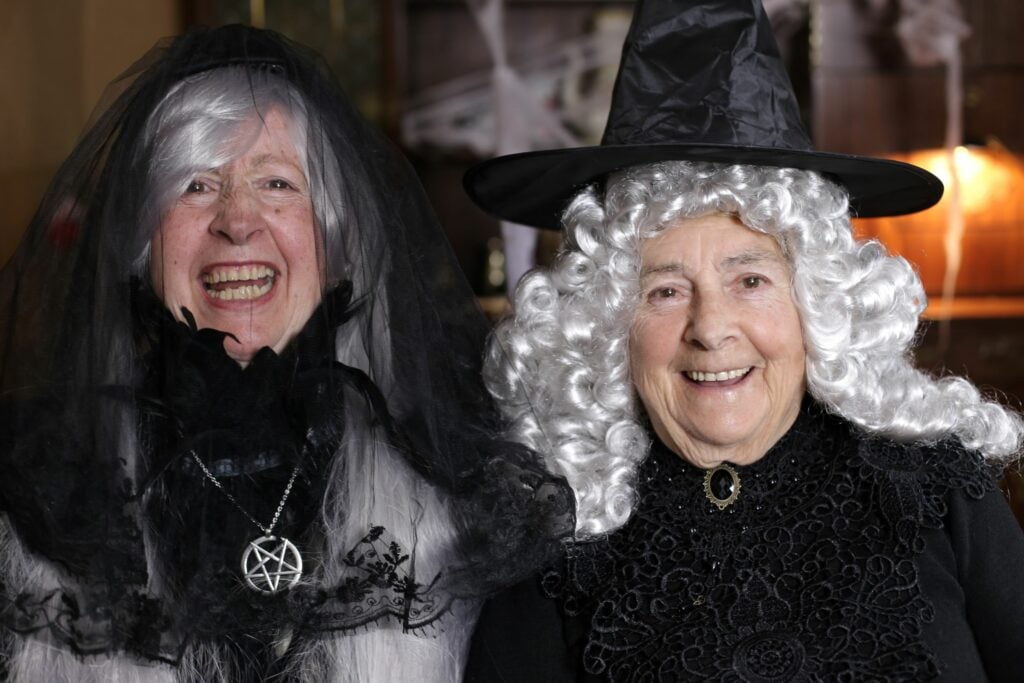Two older women dressed up as witches for Halloween