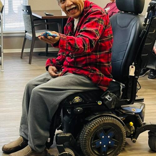 Man on a mobilized wheelchair smiling