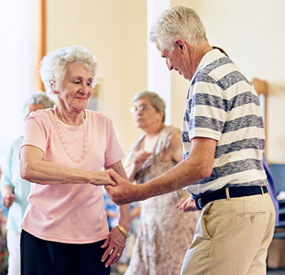 Two seniors dancing at a Sonida senior living community