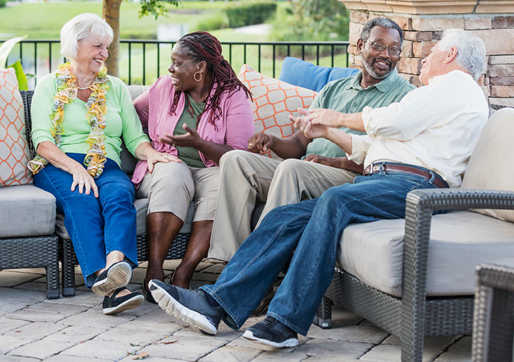 Older adults gathered together talking and laughing at a Sonida senior living community