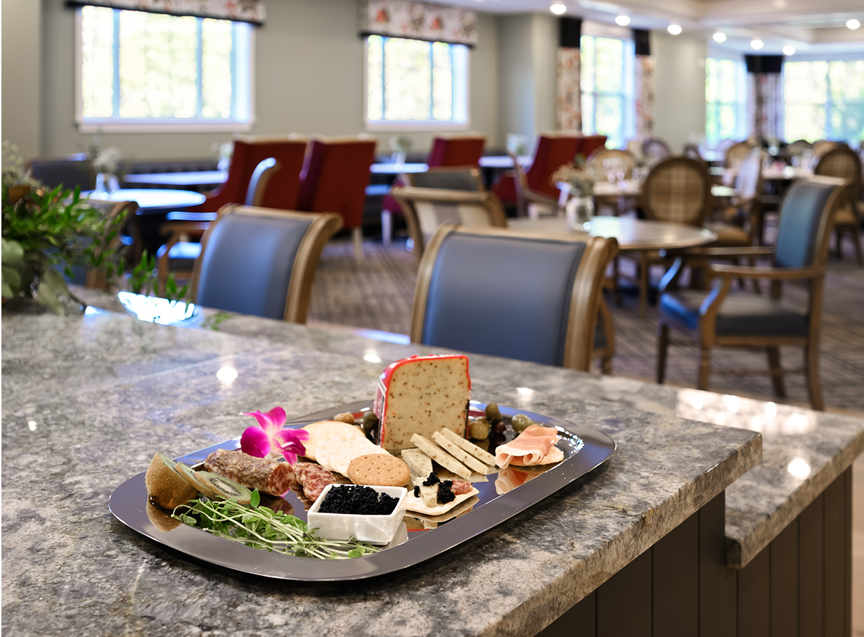 A fruit and cheese plate is displayed in The Ashton at Anderson dining area