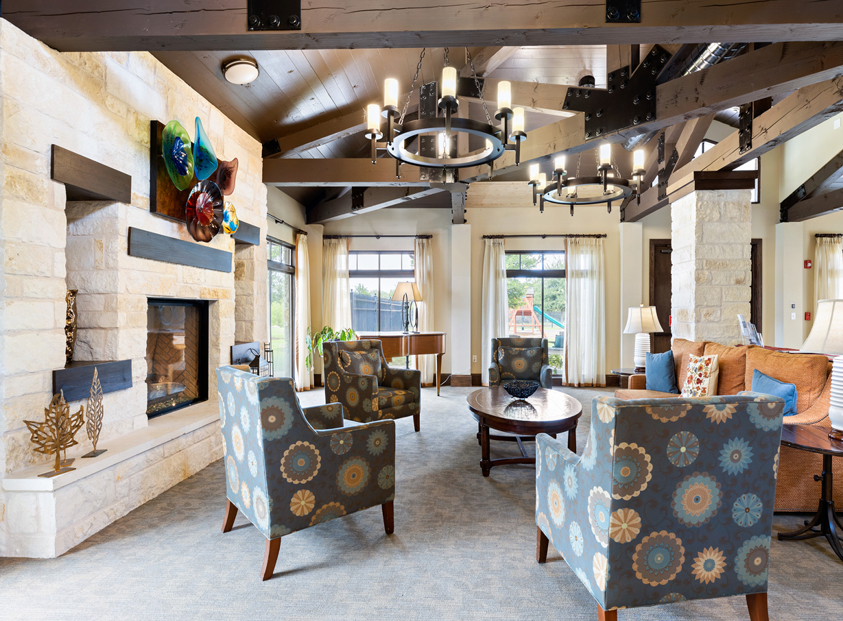 The Waterford at Round Rock lounge area with a fireplace, piano, and many comfortable seats