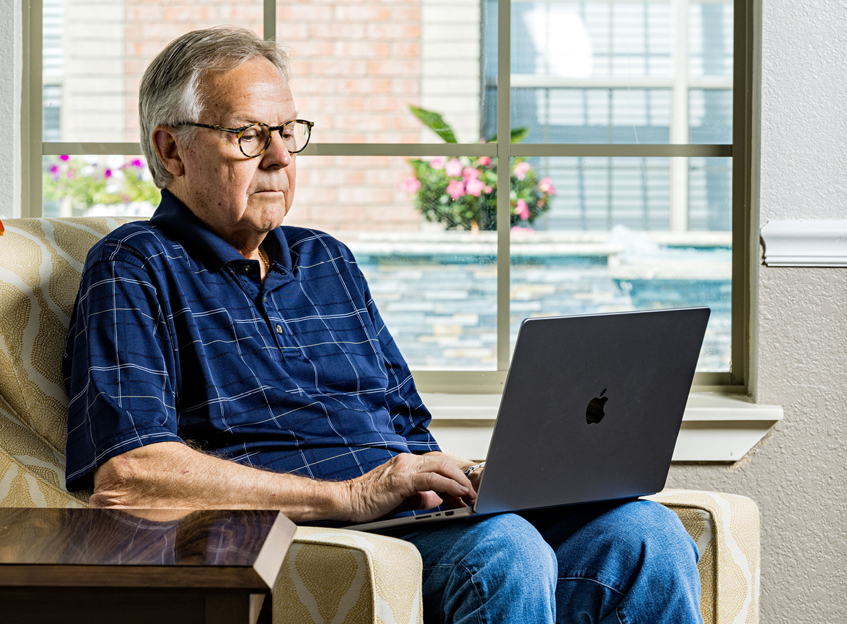 A senior man researching on his laptop how much senior living costs
