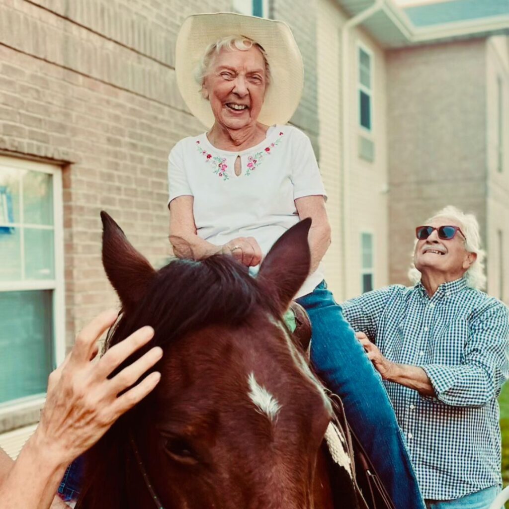 Woman wearing a cowboy hat riding a brown horse