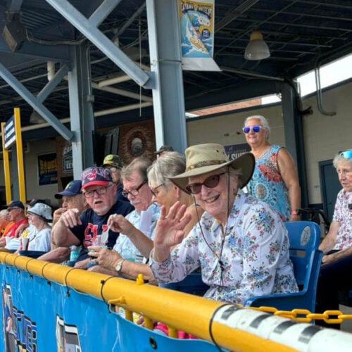 Tree of Dreams wish fulfilled as a resident waves hello to the camera at a baseball game.