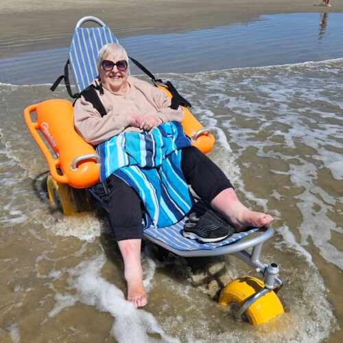 Tree of Dreams wish fulfilled as a resident sits in the ocean sea on a beach.