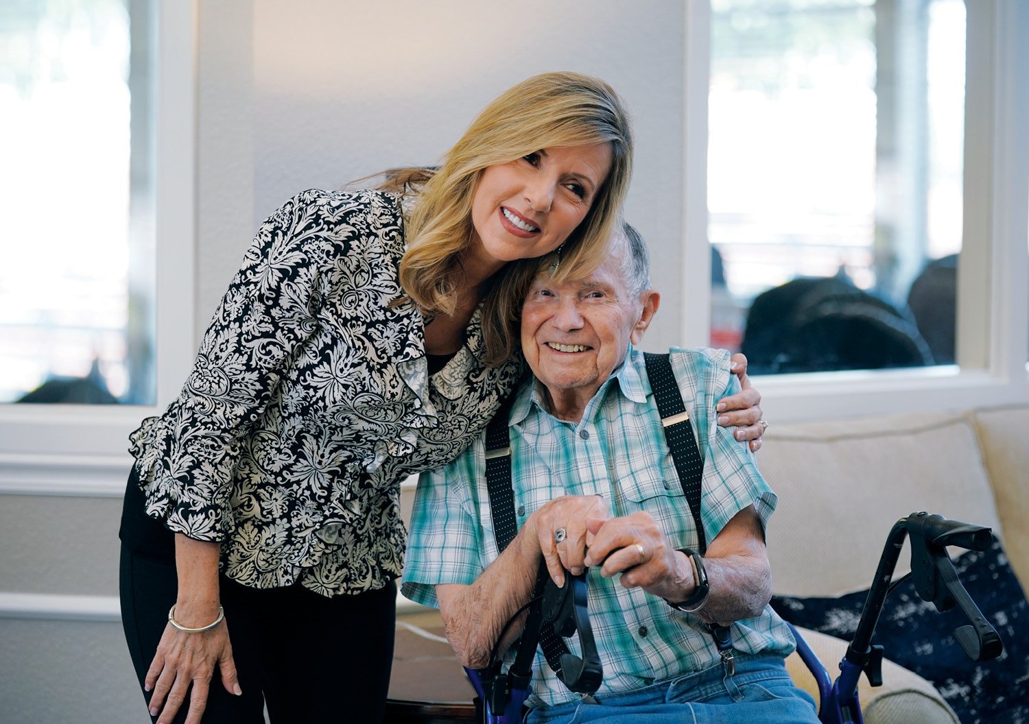 A Sonida Senior Living team member hugging a male resident who is smiling.