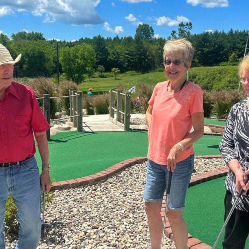 Three seniors enjoying mini golf together