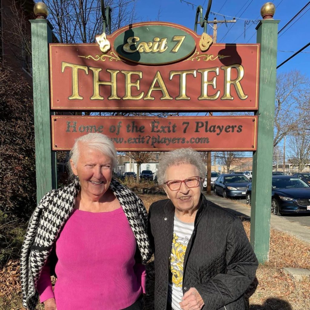 Residents posing in front of theater sign
