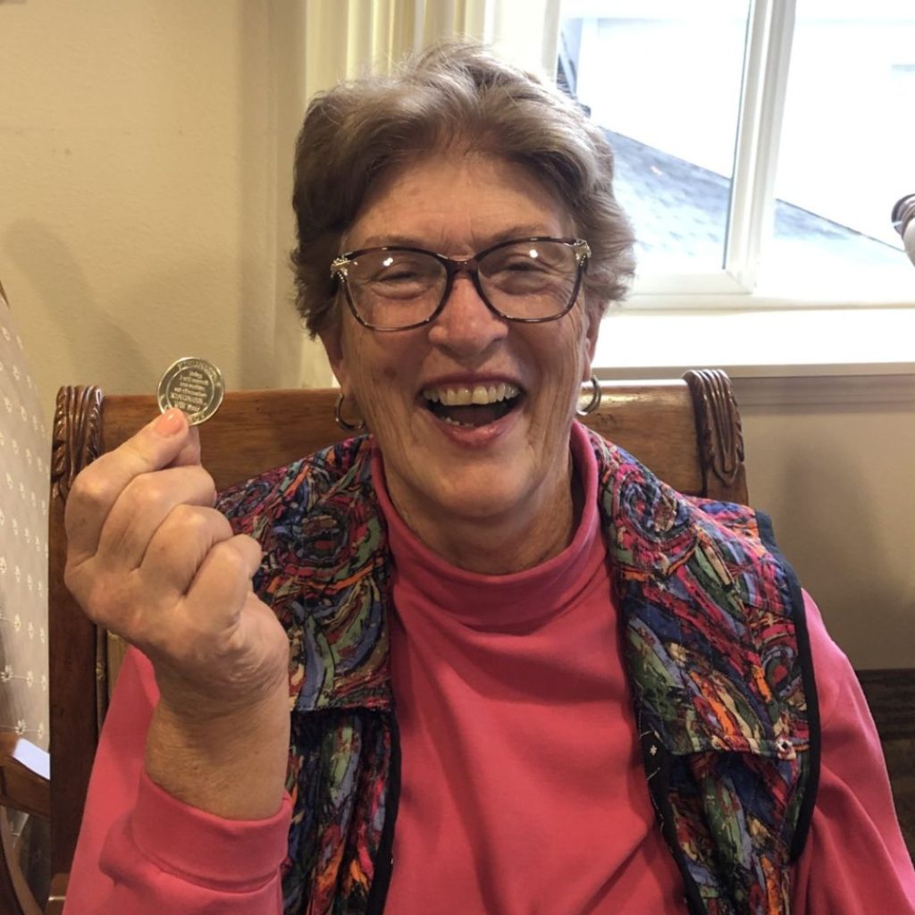 Resident posing with kindness coin