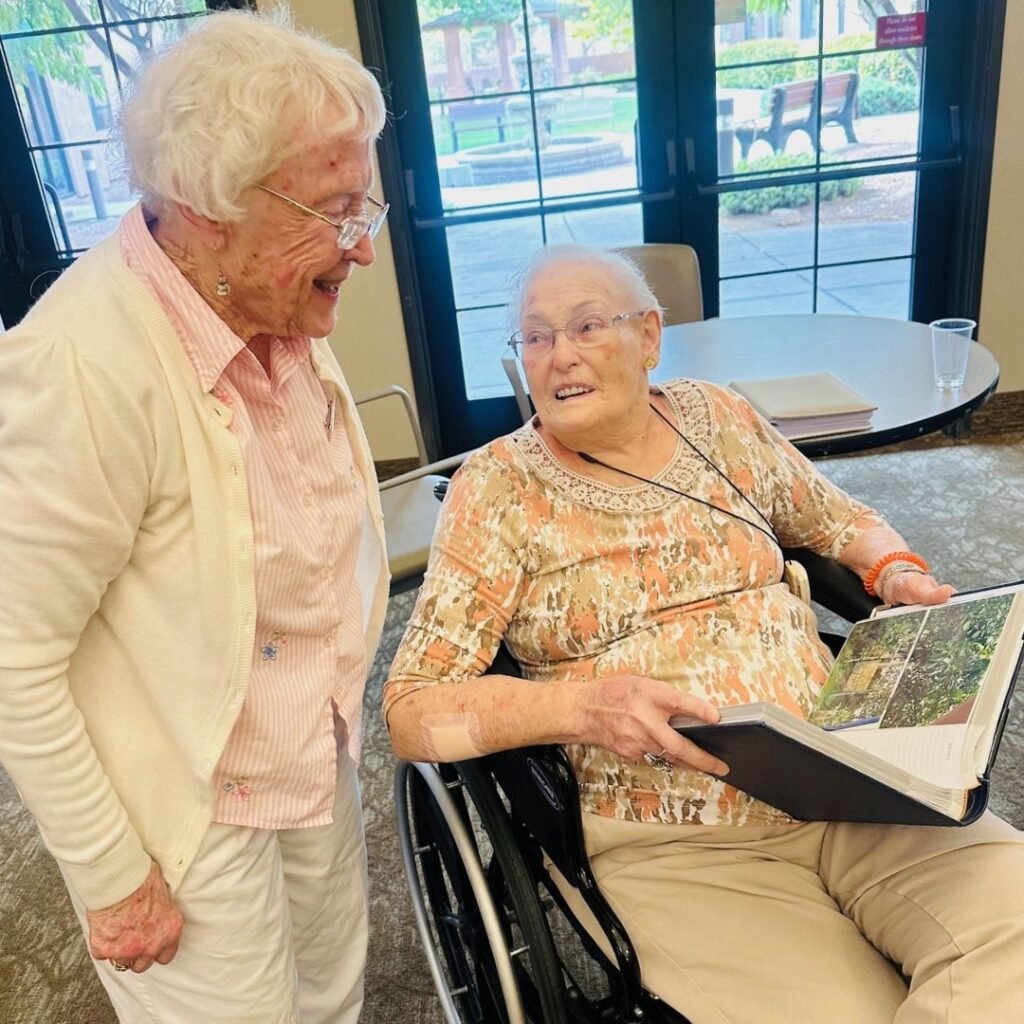 Resident excitedly shows her photo albums to friend, telling a story