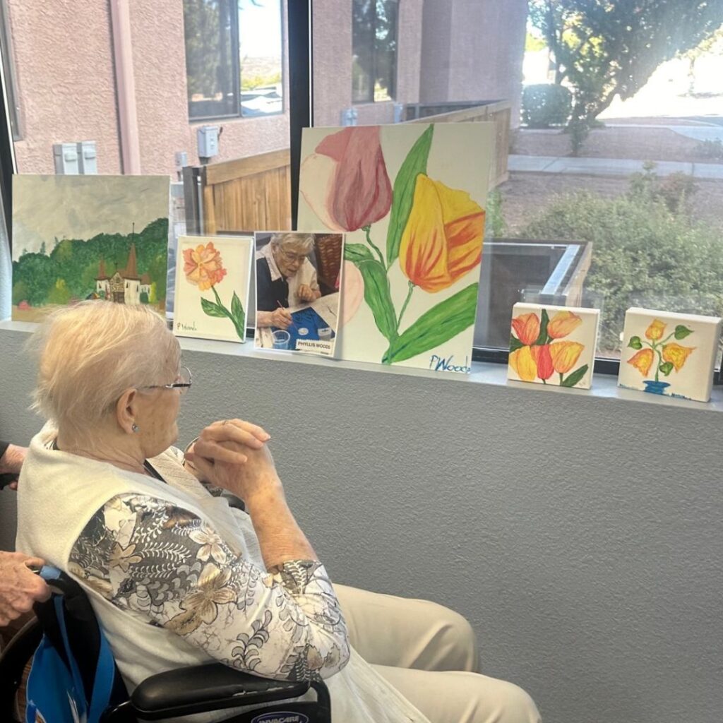 Resident attends art show and enjoys artwork of orange flowers