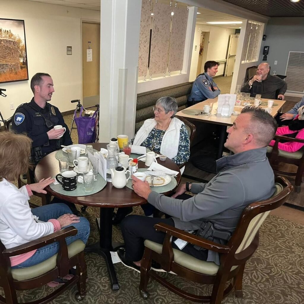 First responders sit with residents in the dining hall for breakfast and conversation