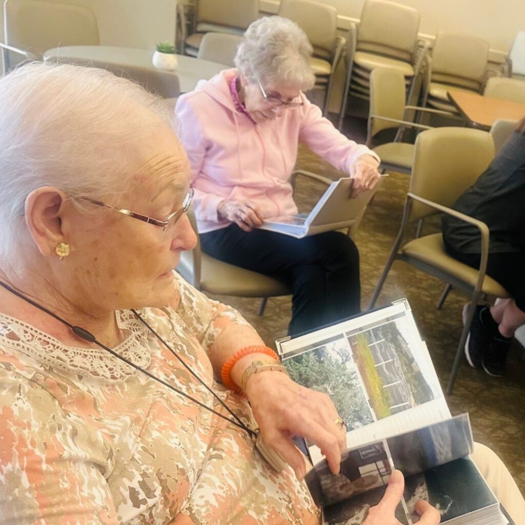 Resident excitedly shows her photo albums to friends