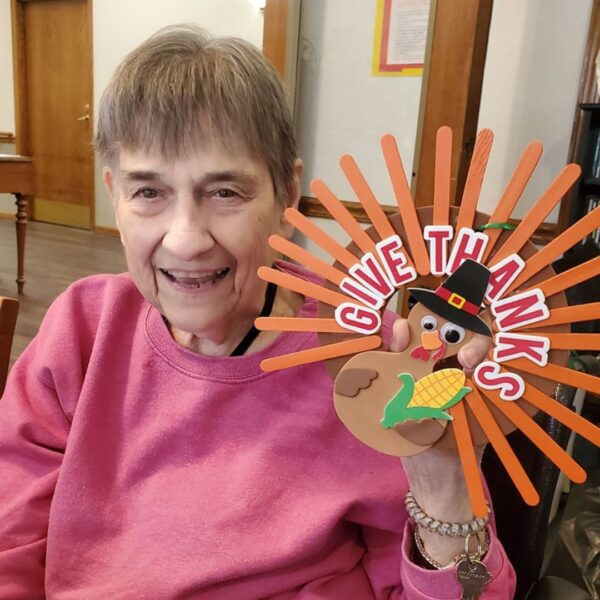 Resident showing turkey craft made for Thanksgiving