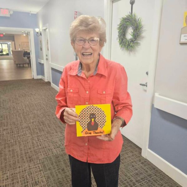 Resident laughing with Thanksgiving turkey craft