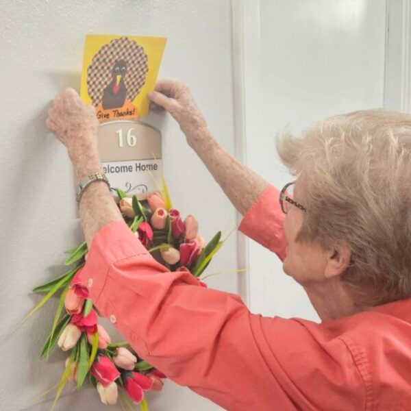 Conroe resident placing craft on her apartment door to greet guests with holiday spirit