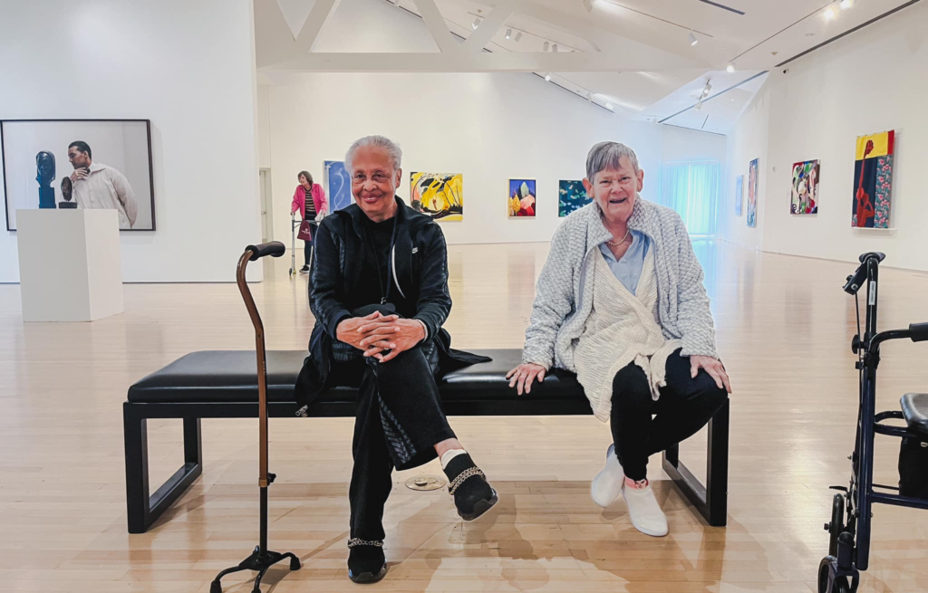 Two residents seated in a contemporary art museum