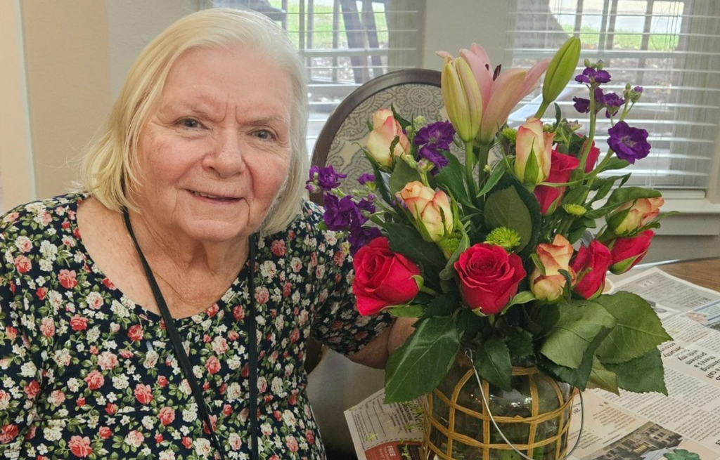 Resident designing floral arrangements for community