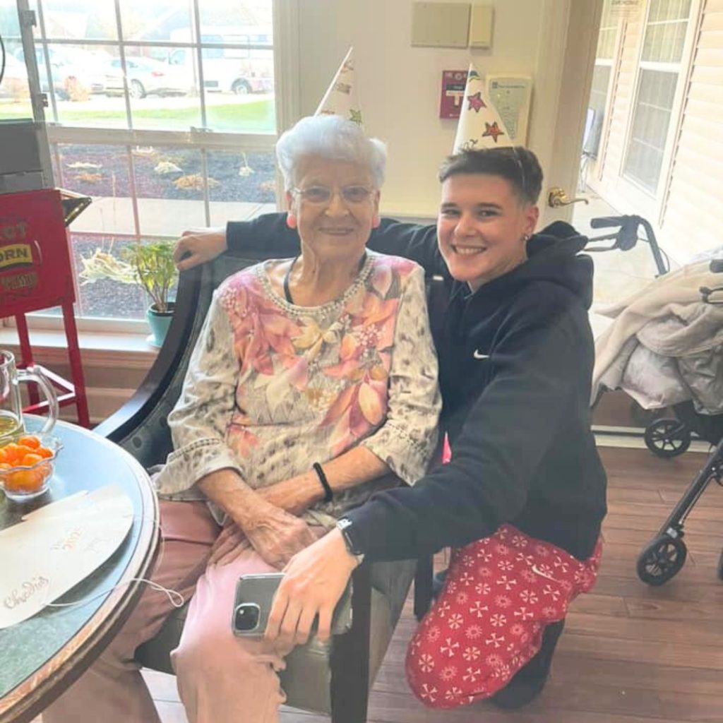 Resident poses with family member while crafting for New Years