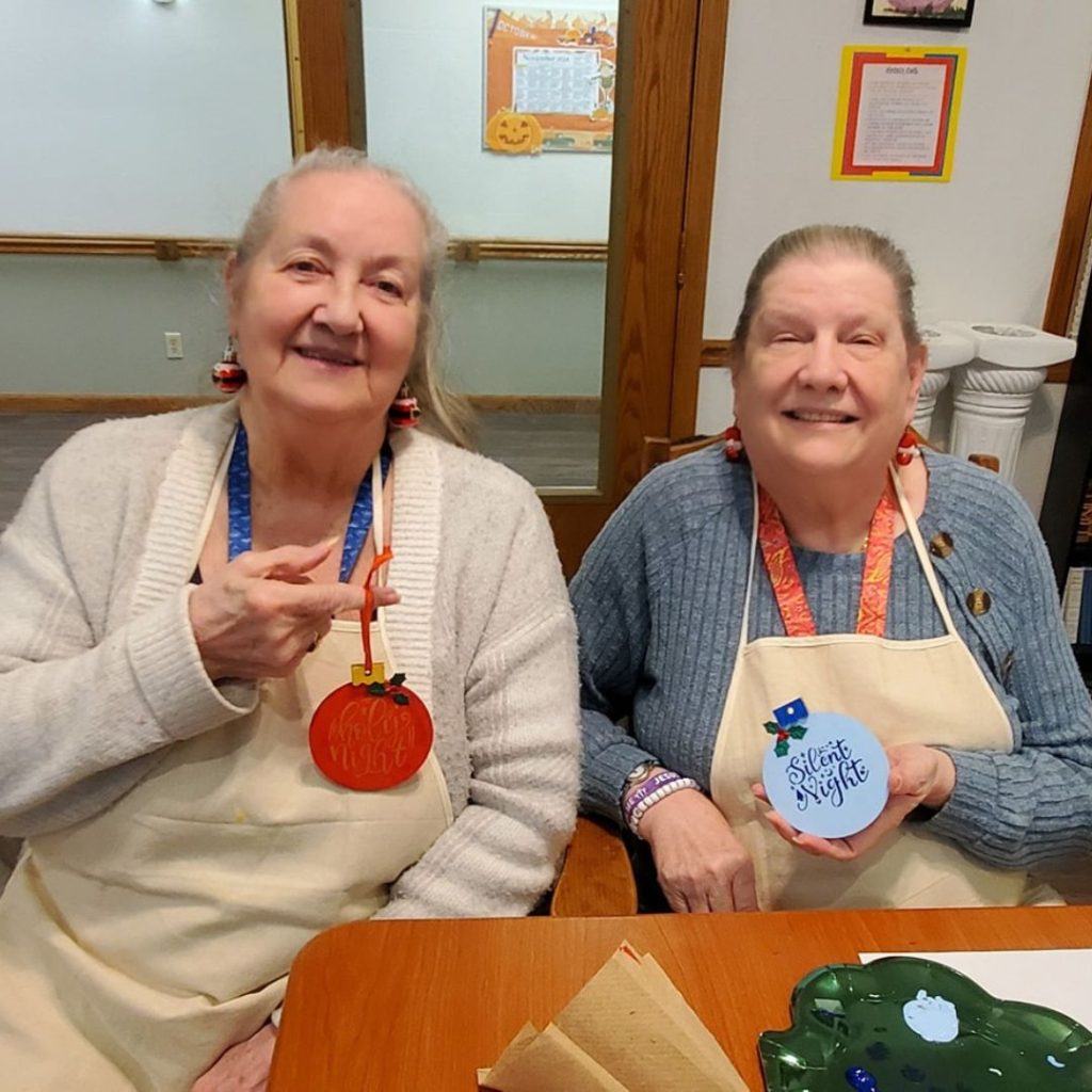 Residents paint custom wooden Christmas ornaments