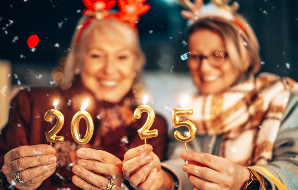 Two senior women celebrate New Years with 2025 candles