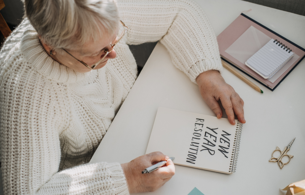 Senior using a planner to track New Years resolution progress
