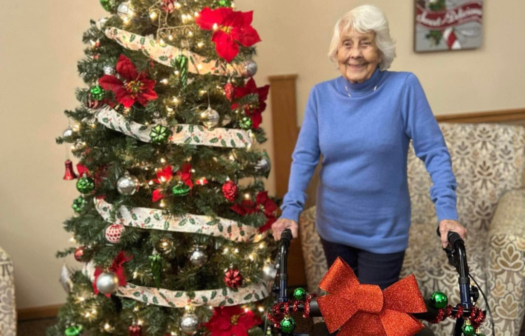 Peggy stands in front of Christmas tree as winner of the decoration contest