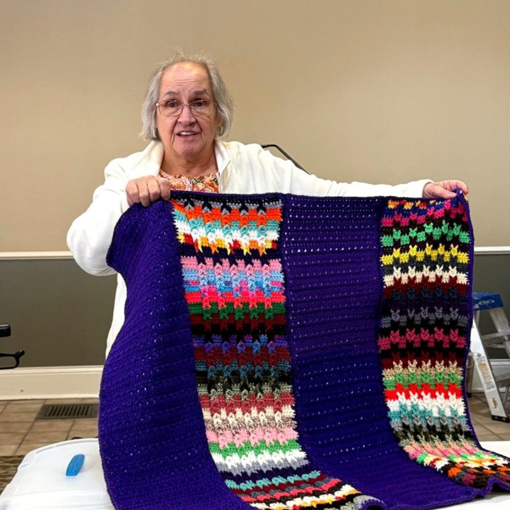 Resident shows off crochet blanket