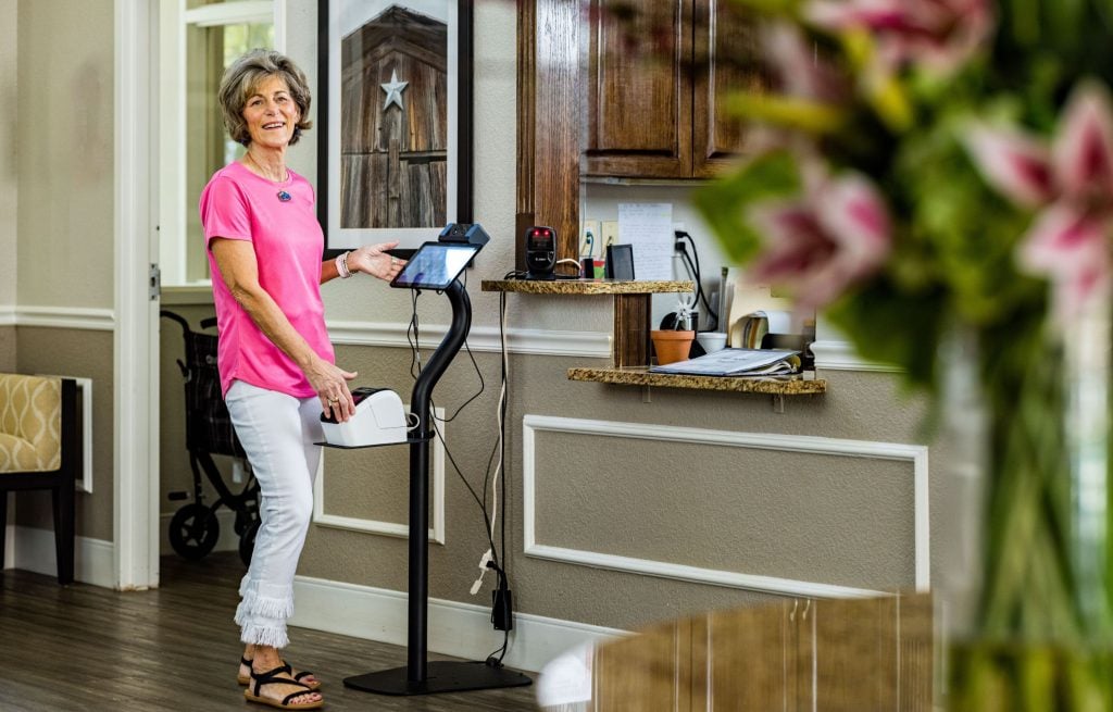 Resident stands before check-in station at community