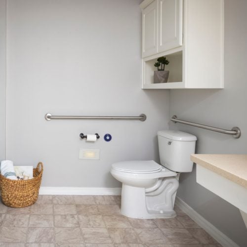 Apartment bathroom with a toilet, shower, sink, and storage at The Waterford at College Station