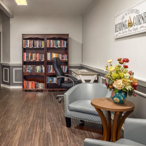A large bookshelf with seating options nearby at The Waterford at College Station