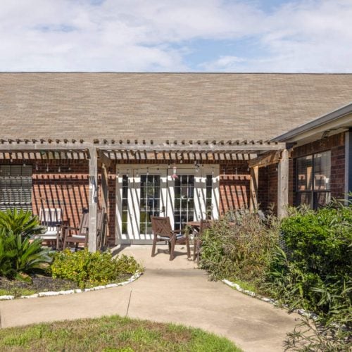 The Waterford at College Station outdoor courtyard with chairs, plants and shaded areas